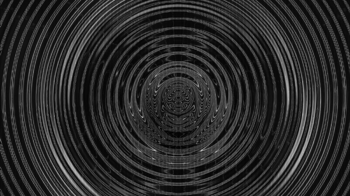 An image of black and grey concentric circles that appear to be moving in a vibration